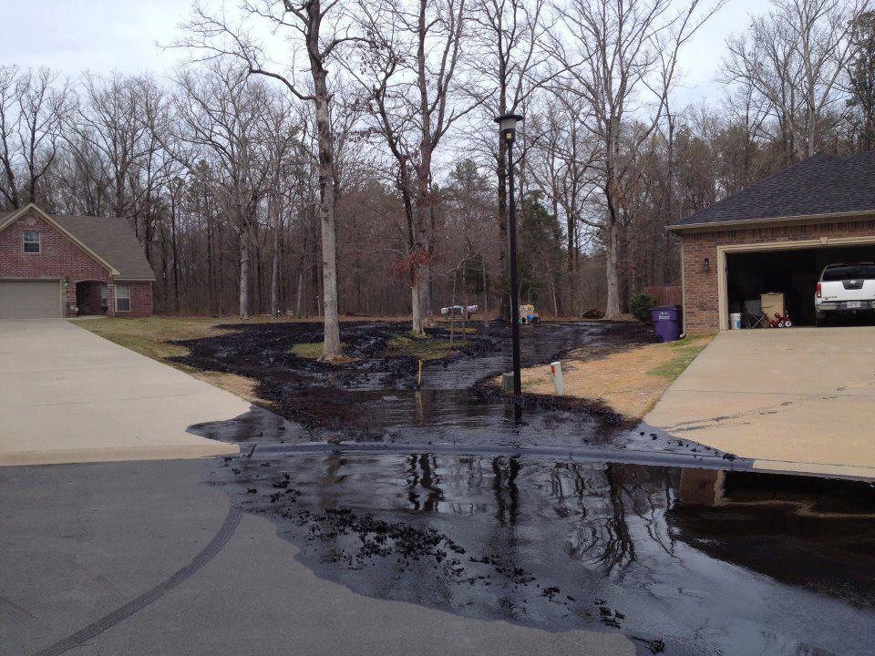 PHoto of Pegasus tar sand pipeline oil spilling between two homes.